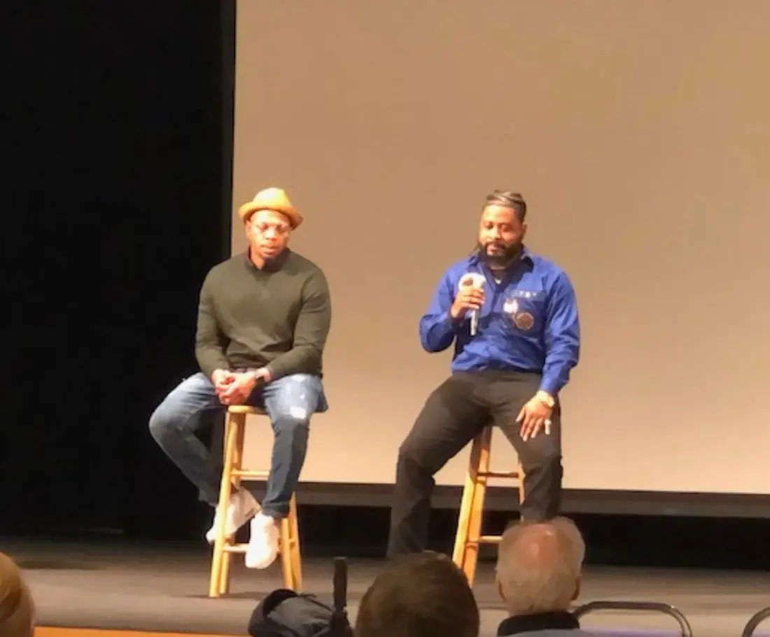 Dru Holley speaking with a collaborator at a film screening