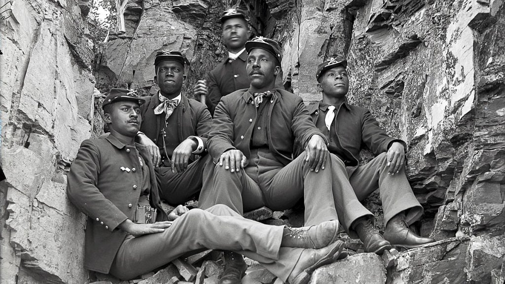 Five Buffalo Soldier reenactors seated among rocks, the photograph featured in EBONY’s article on Dru Holley